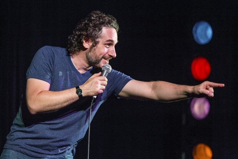 Tom Stade in a blue T-shirt pointing at the crowd