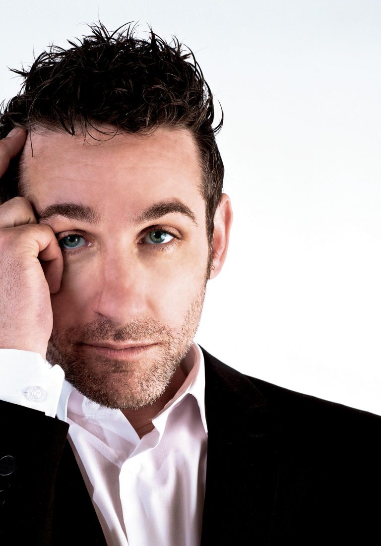 Tom Stade headshot on white, head resting on his hand