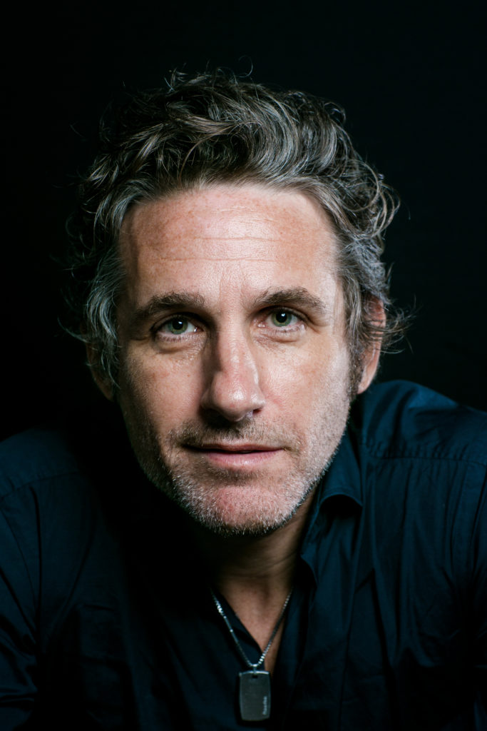 Tom Stade headshot against a dark background