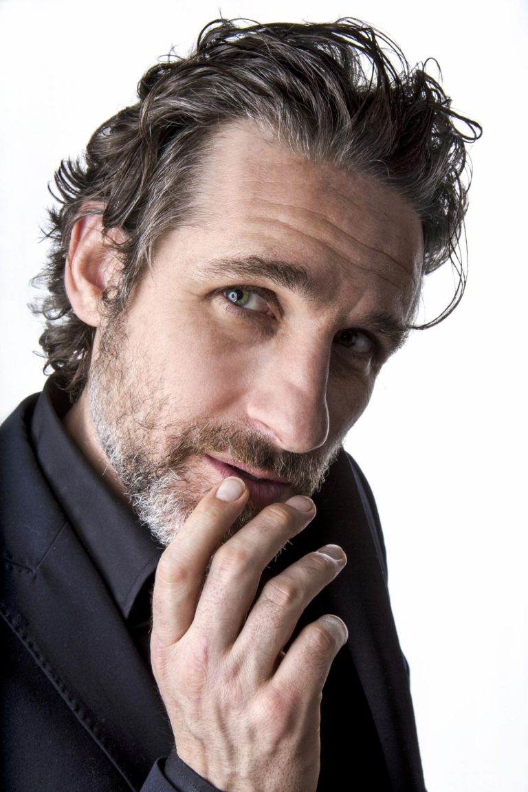 Tom Stade headshot on white, hand on chin