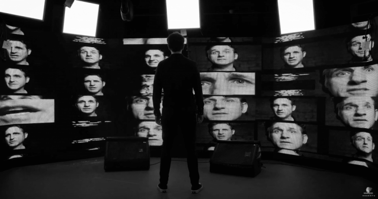 Tom Stade's face appears on multiple television screens