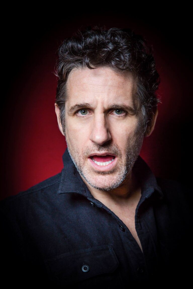 Tom Stade portrait against a red background